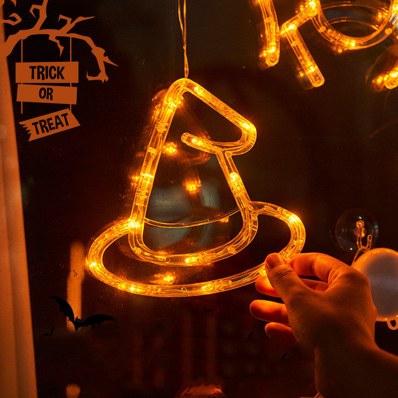 Hanging LED light decoration shaped like a witch's hat with 'Trick or Treat' sign in the background.