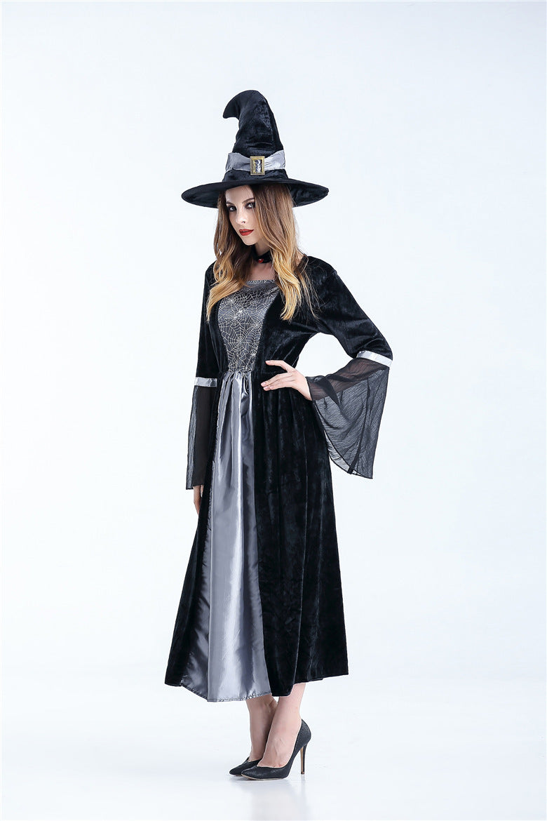 Person wearing a black witch costume with a silver dress on a white background