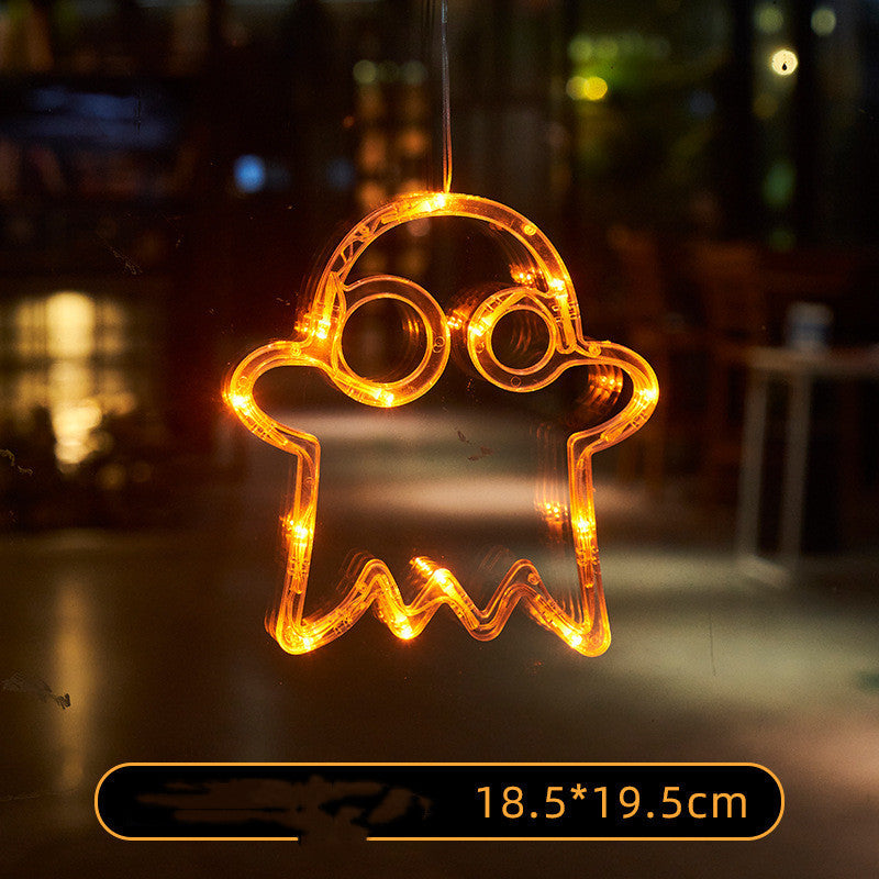 Decorative light shaped like a ghost with glowing orange lights on a dark background.