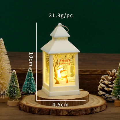 Decorative lantern with 'Merry Christmas' message on a wooden base, surrounded by small trees and pinecones.