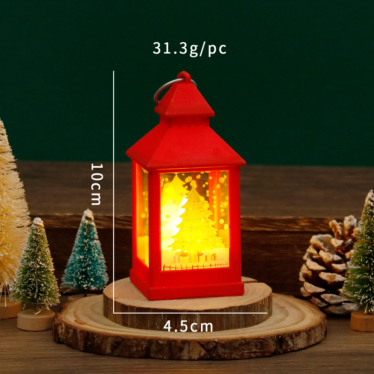 Red lantern with a glowing interior on a wooden base, surrounded by decorative trees and pine cones, with measurements and weight displayed.