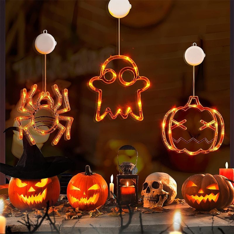 Halloween-themed decorations including lit jack-o'-lanterns, skull, and ghost lights on a dark background.