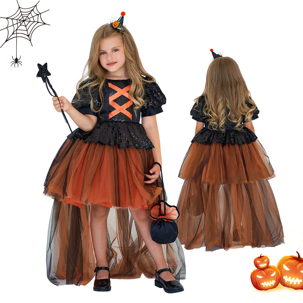 Child in a Halloween costume with black and orange dress, holding a wand and bag.