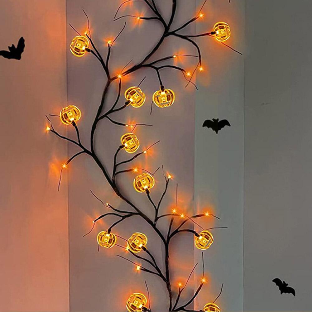 Decorative Halloween light branch with glowing pumpkins on a plain background
