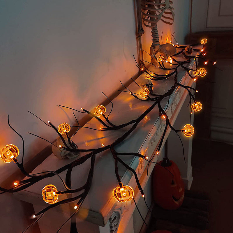 Decorative string lights with pumpkin-shaped bulbs on a mantelpiece with Halloween decorations.