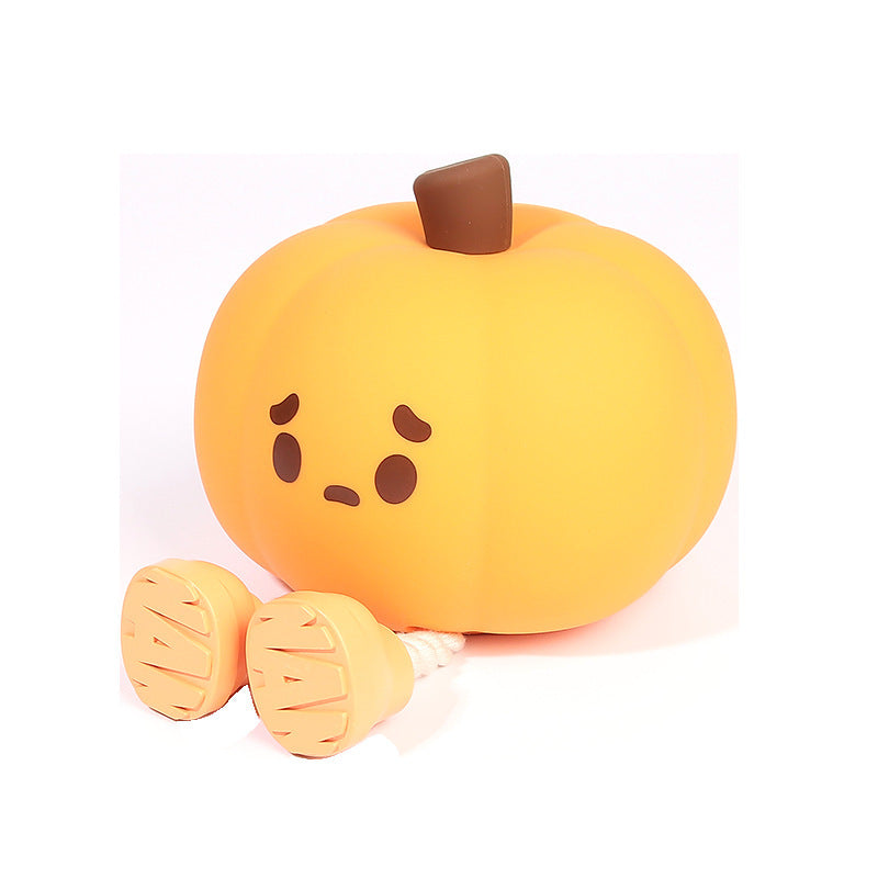 Plush toy shaped like a pumpkin with a sad face on a white background